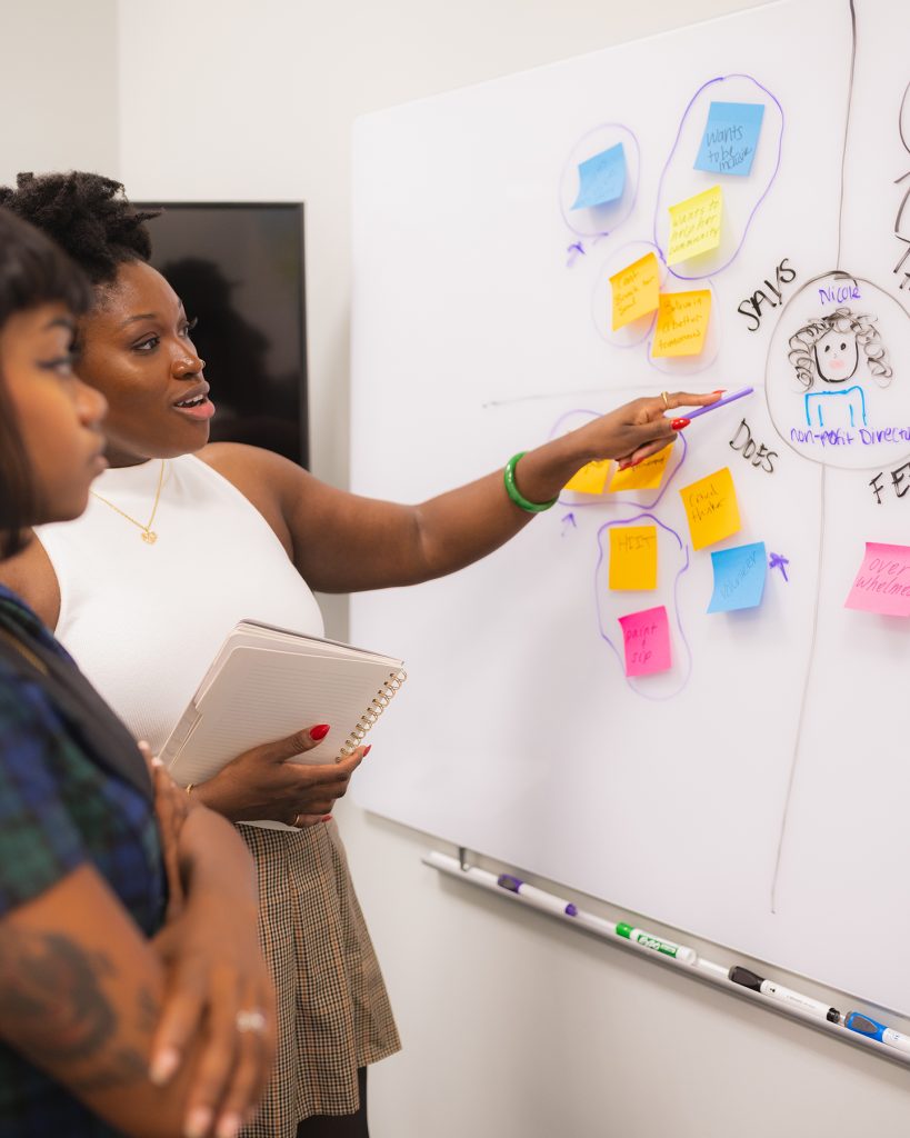 Keisha pointing to sticky notes on an empathy map